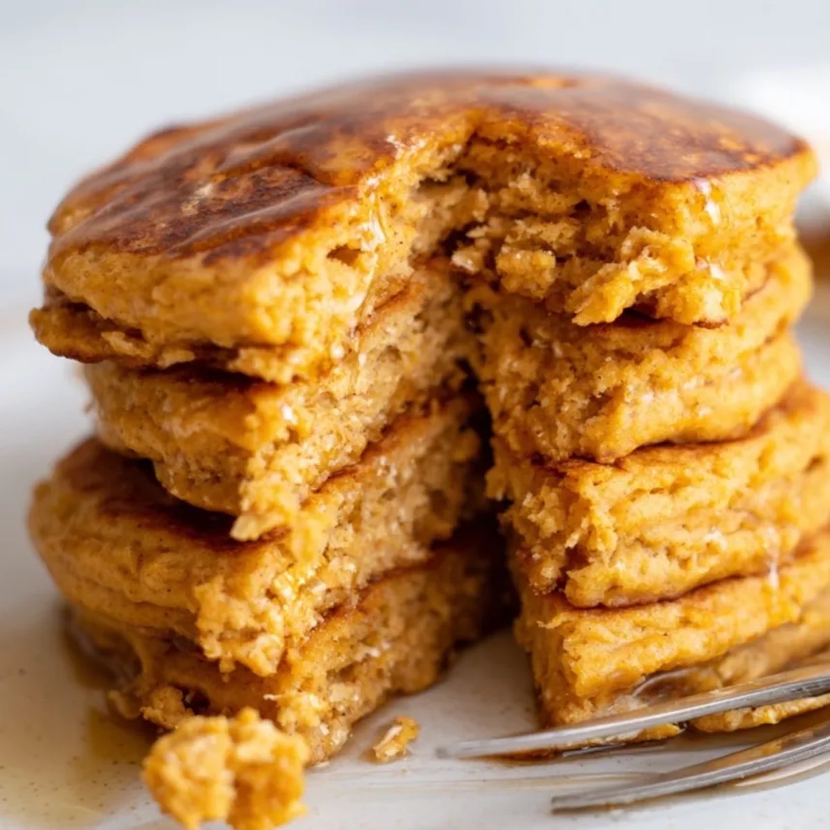 Golden Cinnamon Sweet Potato Protein Pancakes stacked high, begging for a drizzle of maple.