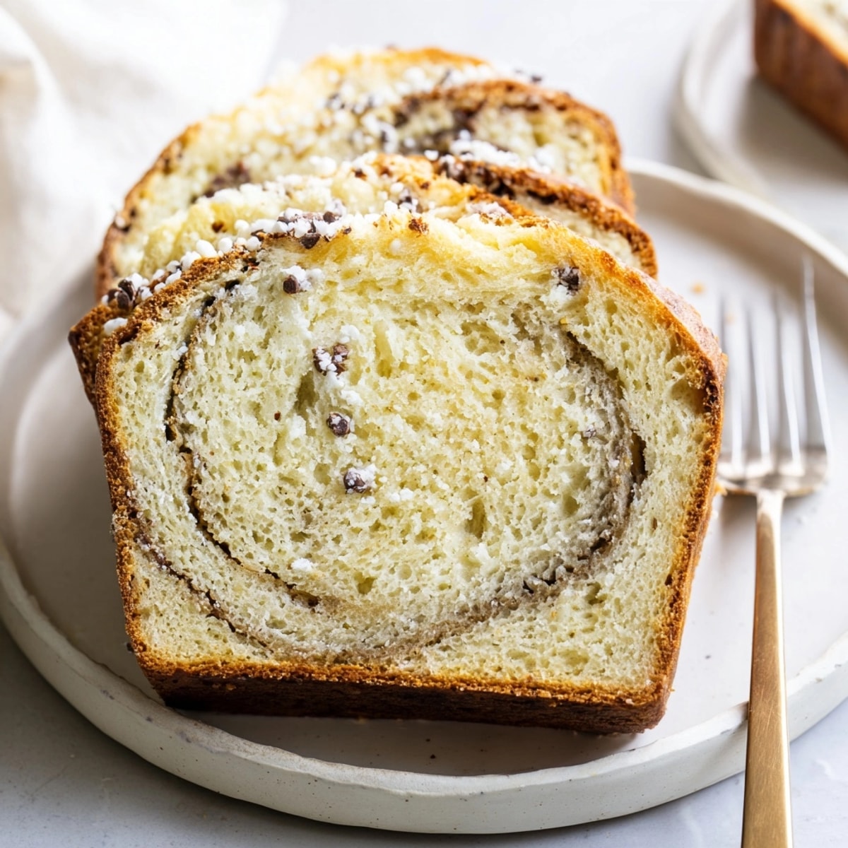 Golden-brown slice of Ricotta Vanilla Bean Bread, speckled with vanilla, ready to eat.