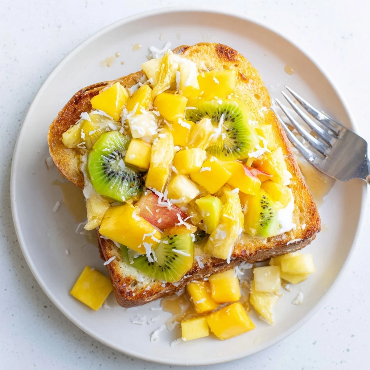 Vibrant yogurt-custard toast, bursting with fresh mango, kiwi, and pineapple flavors.  