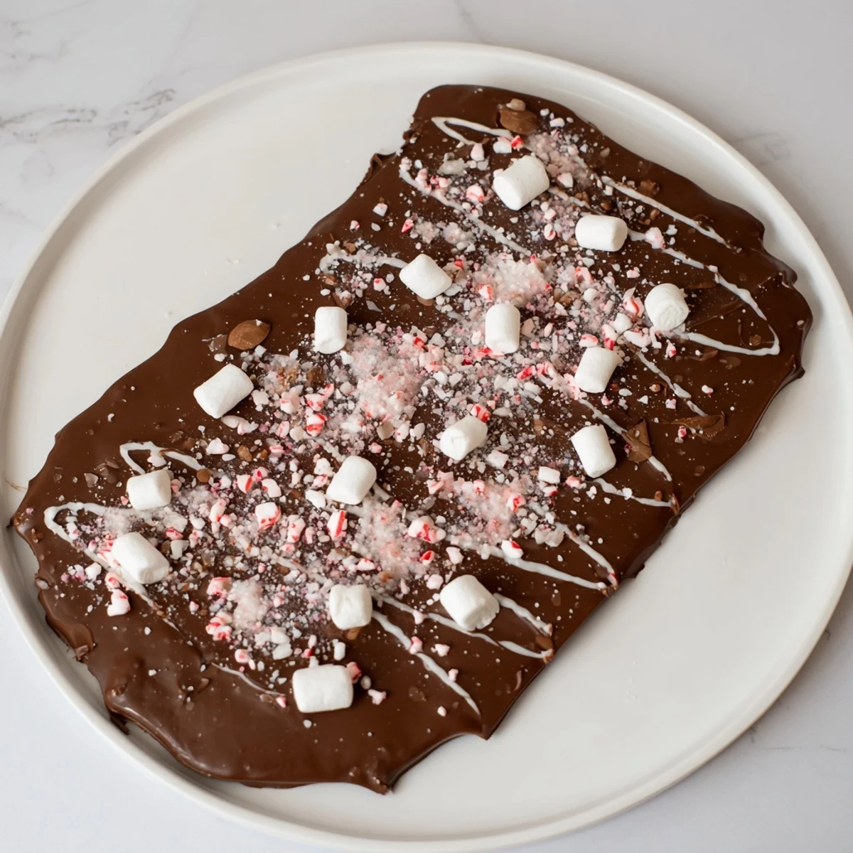 Homemade Hot Chocolate Bomb Bark, a festive treat with mini marshmallows and peppermint pieces drizzled.