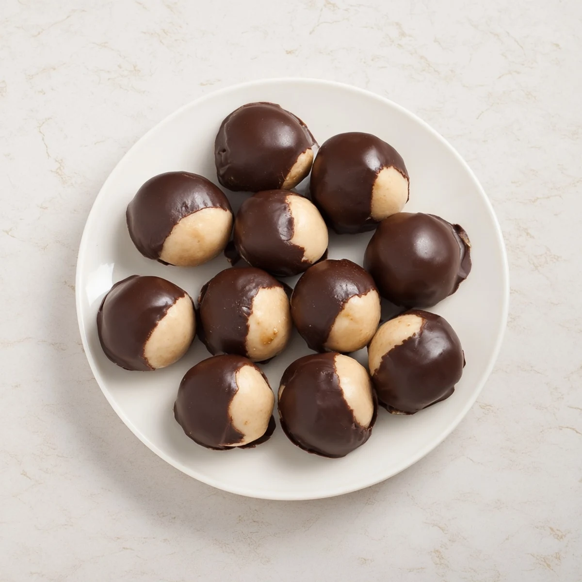 Creamy peanut butter buckeyes, partially dipped in chocolate, perfect for holiday dessert tables.