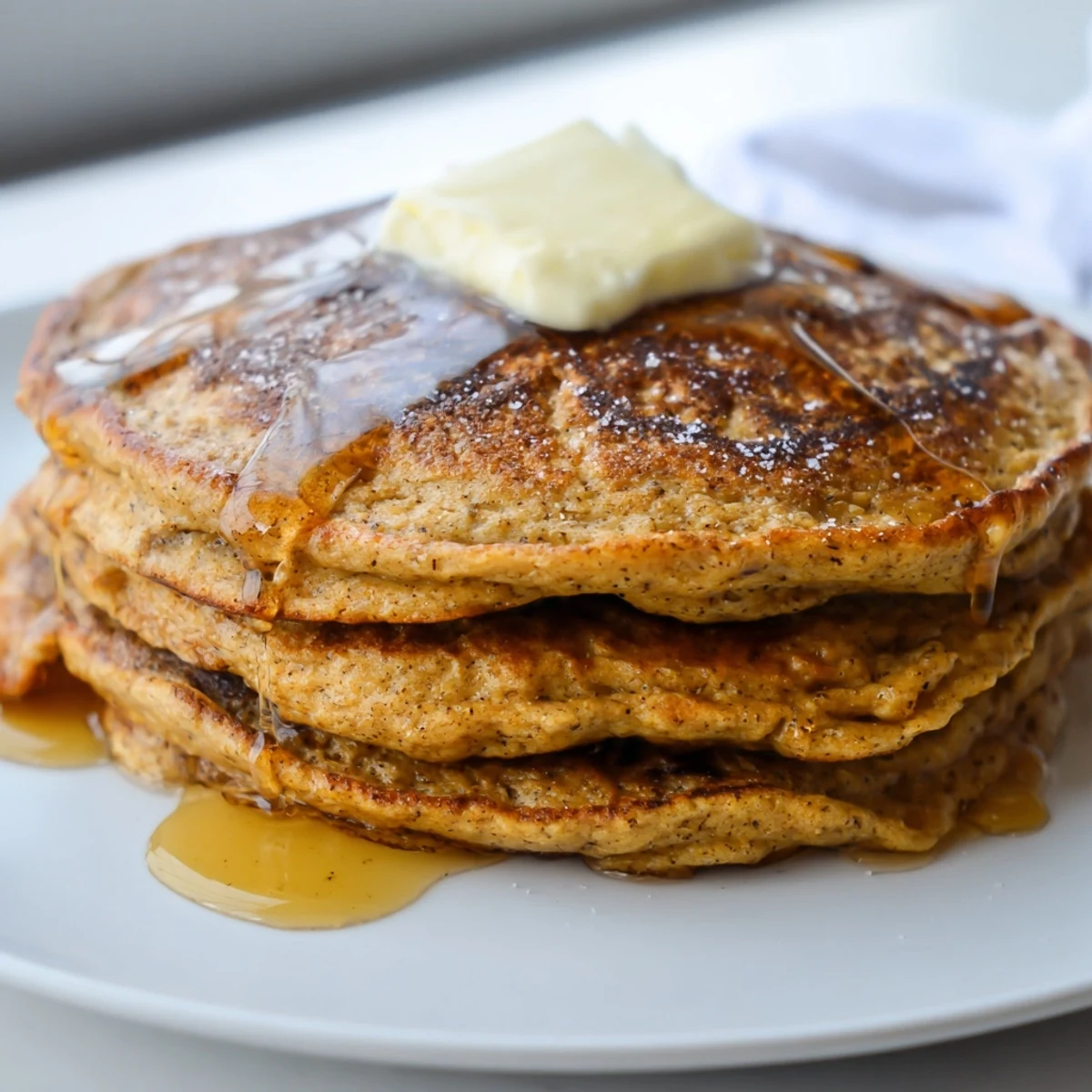 Golden Gingerbread Pancakes, drizzled with maple syrup, promise a delightfully spiced breakfast treat.