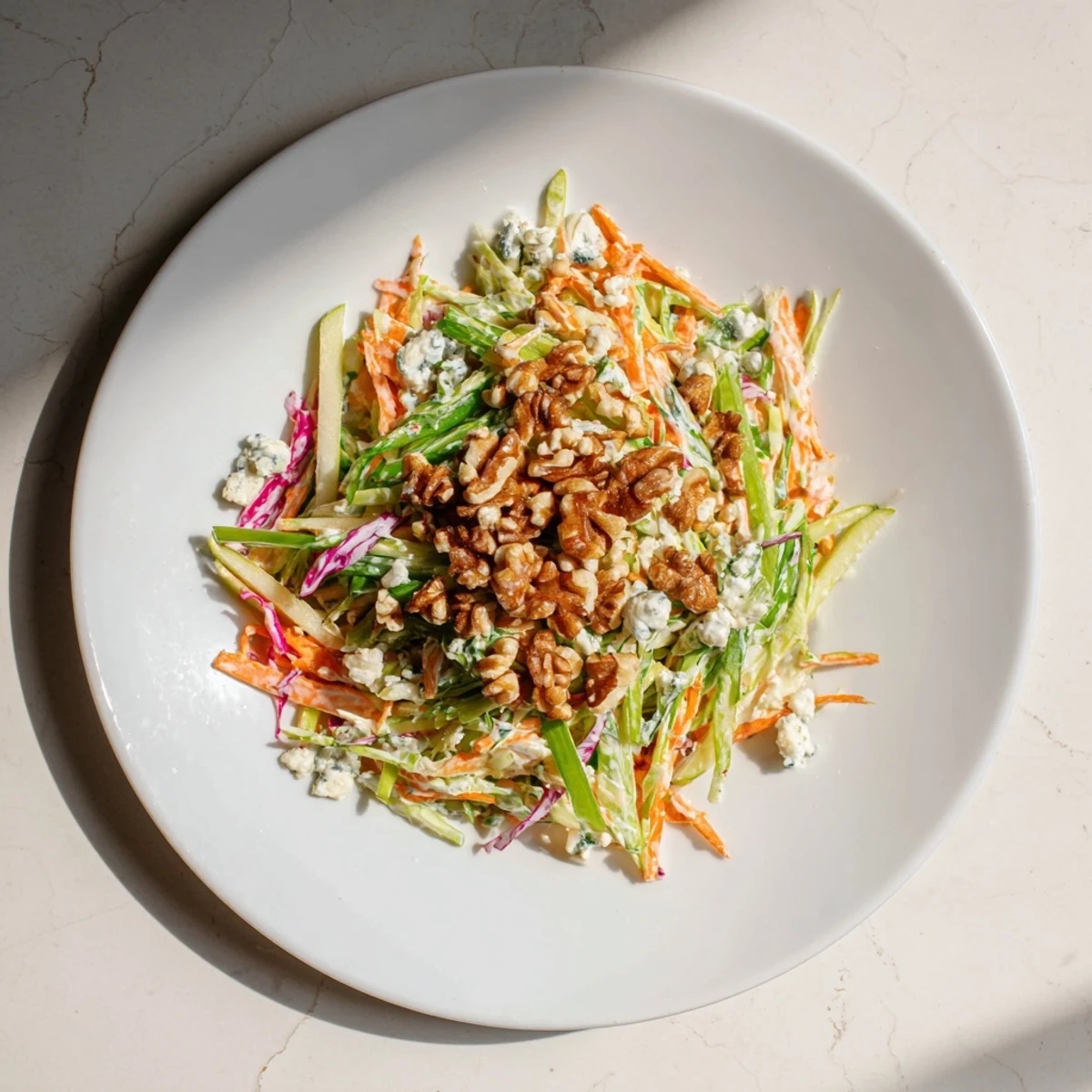 Fresh, crunchy Apple & Walnut Slaw with vibrant colors and creamy blue cheese crumbles, ready to serve.