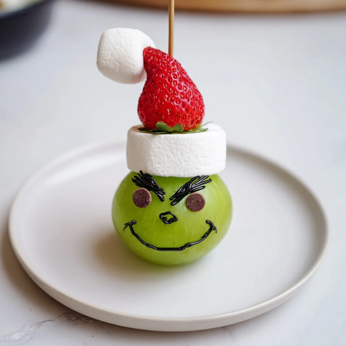 Delectable Grinch Snack featuring green grapes and marshmallow faces, perfect for holiday gatherings.