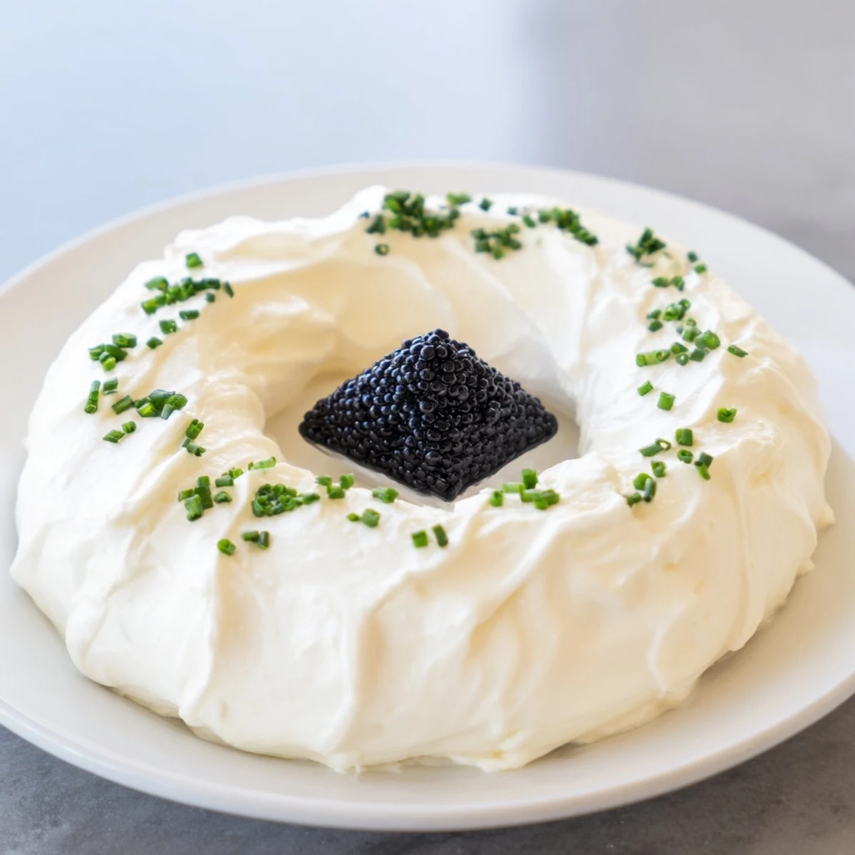 The creamy ring of whipped cream cheese surrounds a diamond of caviar in this Diamond Inlay creation.