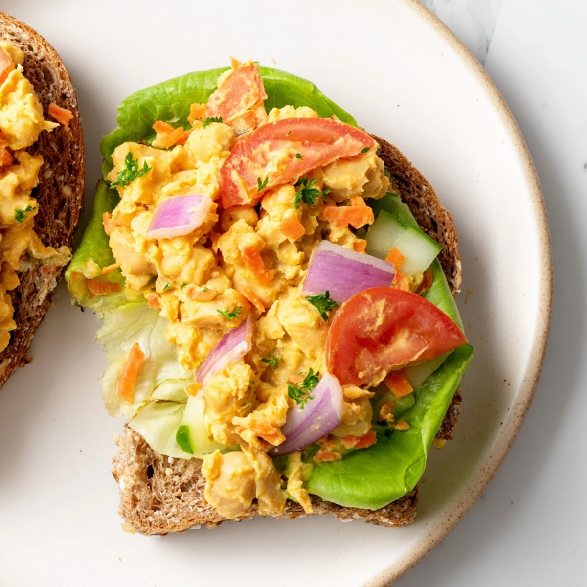 Image Of A Filling Easy Chickpea Salad Sandwich with visible fresh, colorful vegetables and creamy filling.