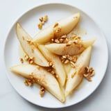 Thinly sliced pears with a drizzle of honey, ready for a quick, gluten-free snack.