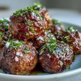 Golden brown Slow Cooker Peach Glazed Meatballs in a bubbling sweet chili sauce, served with toothpicks.