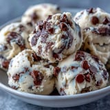 A chilled bowl of Greek Yogurt Cookie Dough reveals its creamy, scoopable texture topped with chocolate chips.