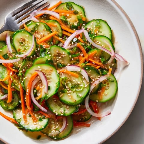 Refreshing cucumber salad remix with vibrant colors and tangy flavors, served chilled.  