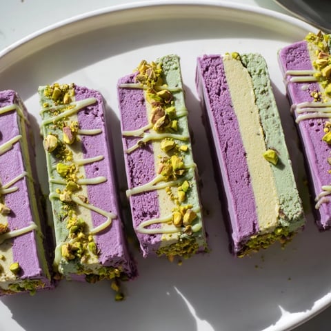 Creamy ube and pistachio ice cream bars with nuts, perfect for summer enjoyment.  
