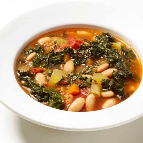 Steaming bowl of Italian Bean & Kale Stew, showcasing tender beans and vibrant green kale.