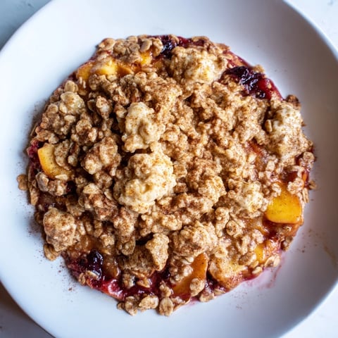 Golden, bubbly Fruit Crisp with frozen berries, topped with crunchy oat crumble, ready to serve warm.