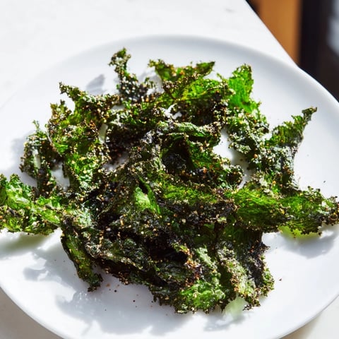 Golden, crispy baked kale chips, a healthy homemade snack with a satisfying crunch and sea salt.