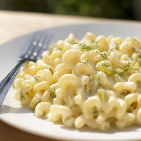 A steaming bowl of Pickle Mac and Cheese, with visible pickle chunks and melted cheese sauce.