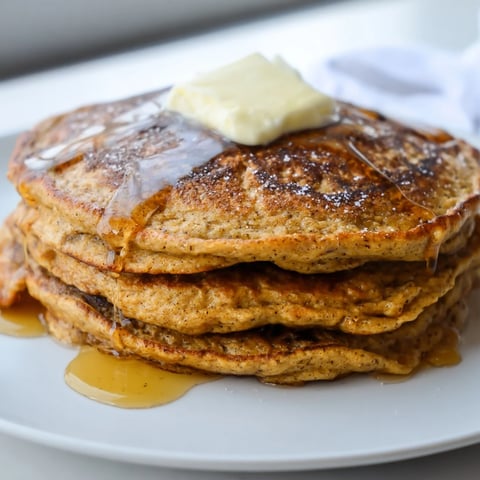 Golden Gingerbread Pancakes, drizzled with maple syrup, promise a delightfully spiced breakfast treat.
