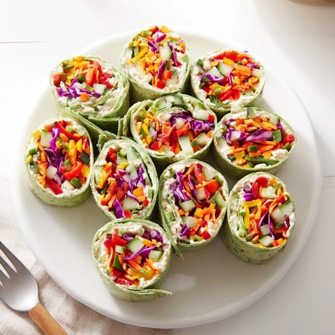 Festive Rainbow Veggie Christmas Lights Wrap Pinwheels, showcasing colorful veggies and creamy filling arrangements.