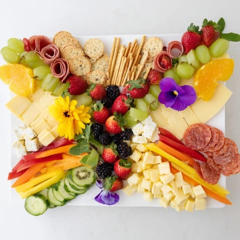 Butterflies of colorful fruits and cheeses on a festive Butterfly Summer Board ready to serve.