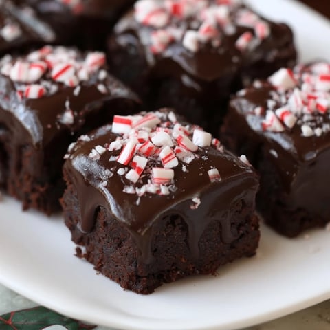 Warm, gooey Peppermint Mocha Brownie Bites, drizzled in rich chocolate, with crushed peppermint flecks.