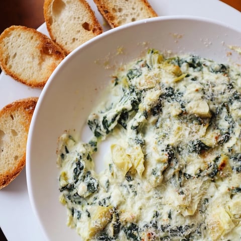 Spinach Artichoke Dip with toasted baguettes, a warm and creamy appetizer ready to eat.