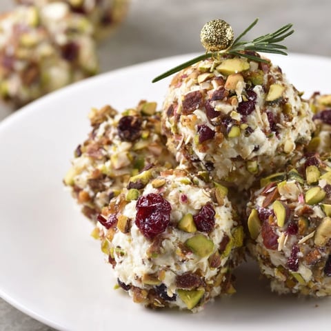 Clusters of colorful Holiday Ornament cheese balls, a festive appetizer perfect for a holiday party.