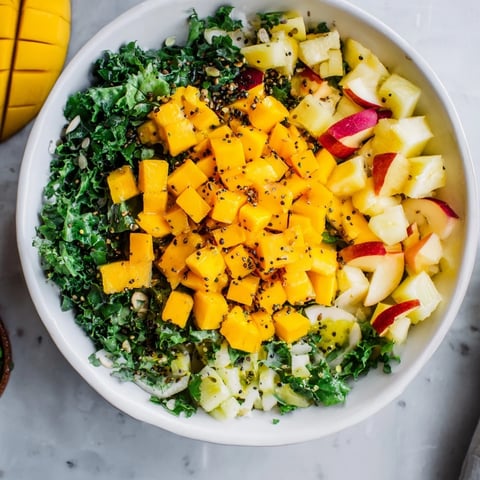 Fresh, vibrant The Sunlit Glade salad, featuring yellow fruit in a bed of bright green herbs.