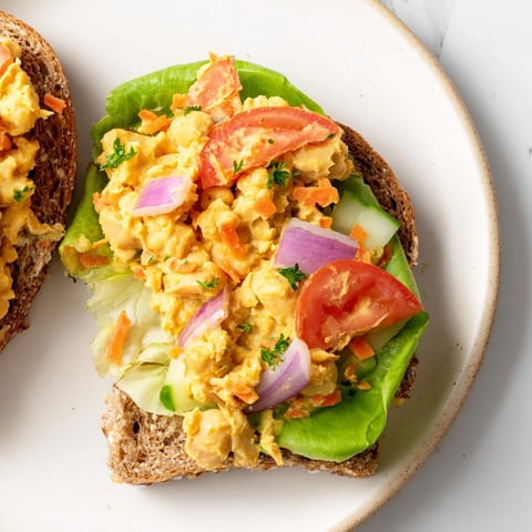 Image Of A Filling Easy Chickpea Salad Sandwich with visible fresh, colorful vegetables and creamy filling.
