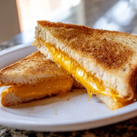 Mayo grilled cheese sandwich, perfectly golden and melty, ready to be sliced and enjoyed.