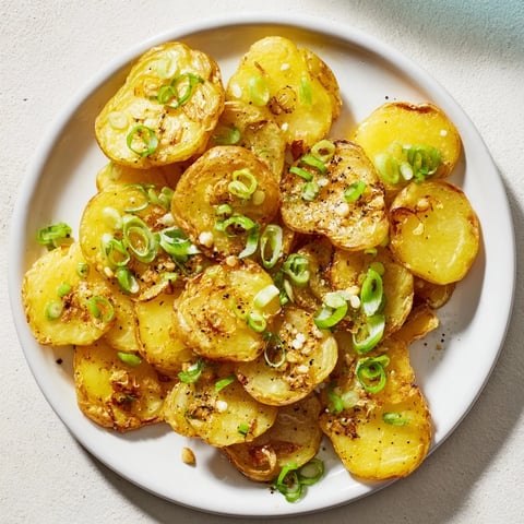 Golden-brown Smashed Green Onion Potato Bombs sizzling on a baking sheet, ready to be devoured.