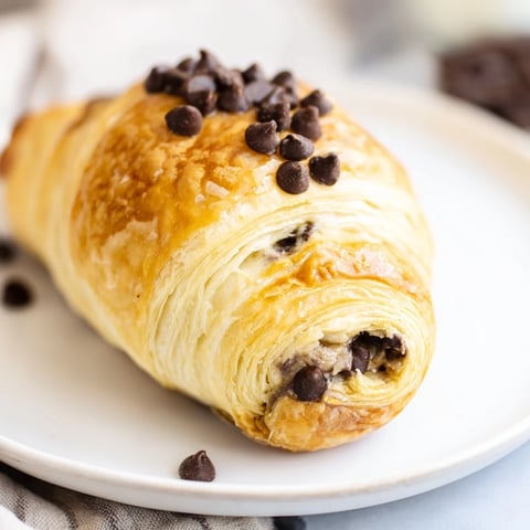 Golden-brown Viral Crookie hybrid, fresh from the oven, showing flaky pastry and melty chocolate.