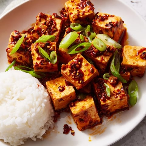 Steaming hot Chinese Mapo Tofu with soft tofu and savory sauce, ready to serve over fluffy rice.