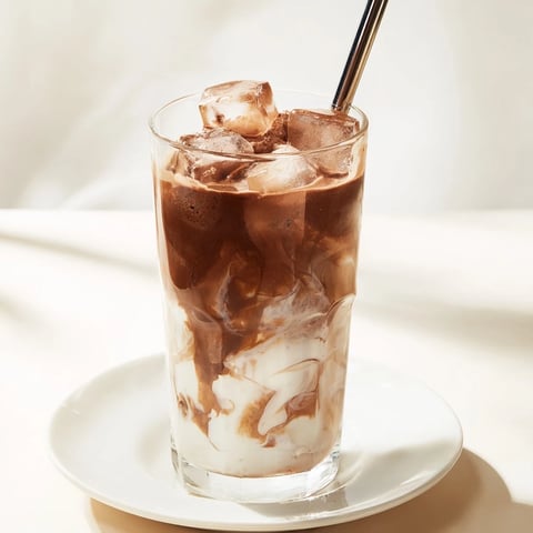 Frothy Milo Ice Latte, a quick and easy drink, swirls with rich chocolate flavors over ice.
