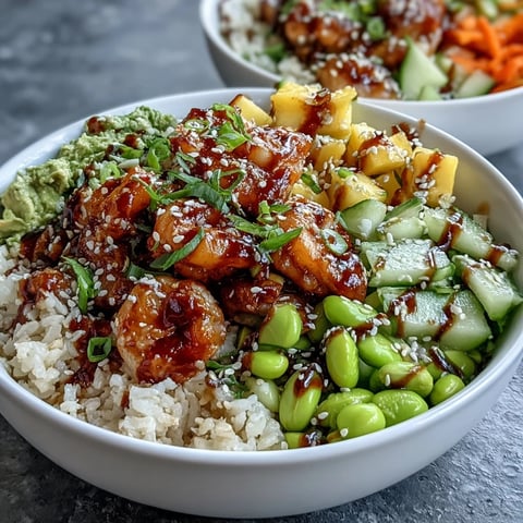 Freshly cooked shrimp, diced mango, and avocado slices topped on brown rice in a 20-Minute Shrimp Poke Bowl with Mango and Edamame.