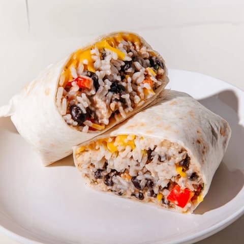 A close-up of a perfectly wrapped Freezer-Friendly Burrito, showing a delicious, hearty filling.