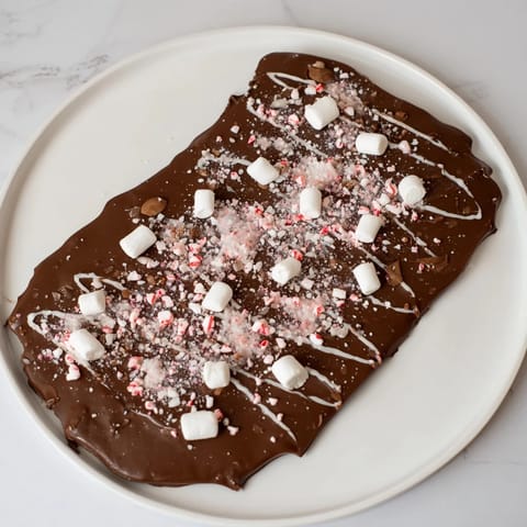 Homemade Hot Chocolate Bomb Bark, a festive treat with mini marshmallows and peppermint pieces drizzled.