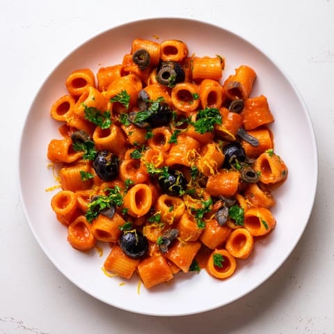 Close-up photo of puttanesca ditalini; the flavorful, cooked pasta dish with fresh parsley garnishing.