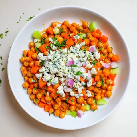 This Buffalo Chicken Bean Salad showcases colorful vegetables and creamy blue cheese, ready to be scooped and enjoyed.