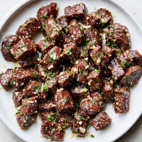 Tender sirloin in the air fryer, coated in garlic-butter, ready to eat as air-fryer garlic-butter steak bites.