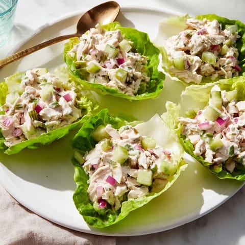 Freshly made dill pickle chicken salad filling bright lettuce cups, ready for a light lunch.