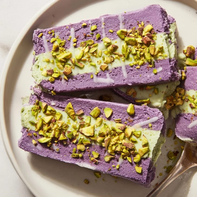 Vibrant ube & pistachio ice cream bars, drizzled with sweetened condensed milk, served chilled.  