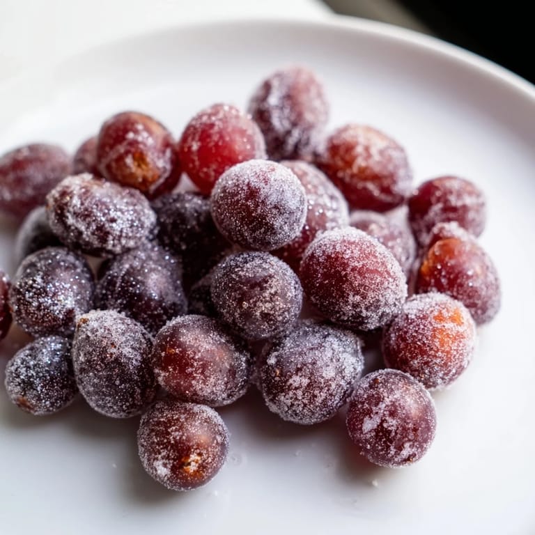Close-up of frozen grape treats: red and green grapes coated in sweetness, ready to eat.