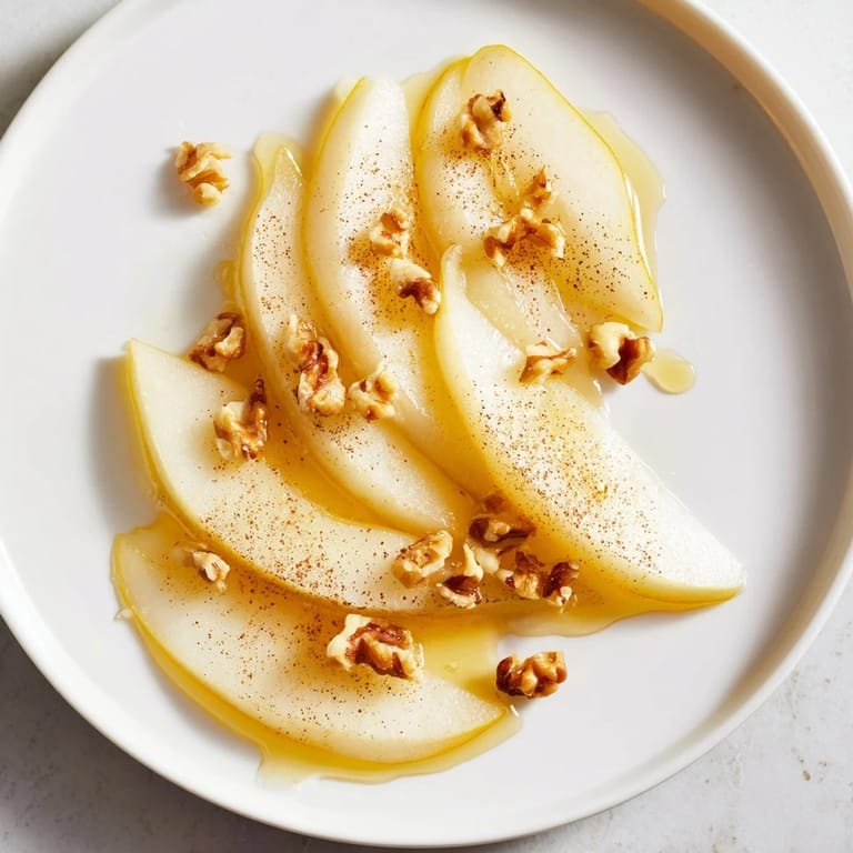 Sweet, juicy pear slices artfully arranged and drizzled with honey, ready to eat.