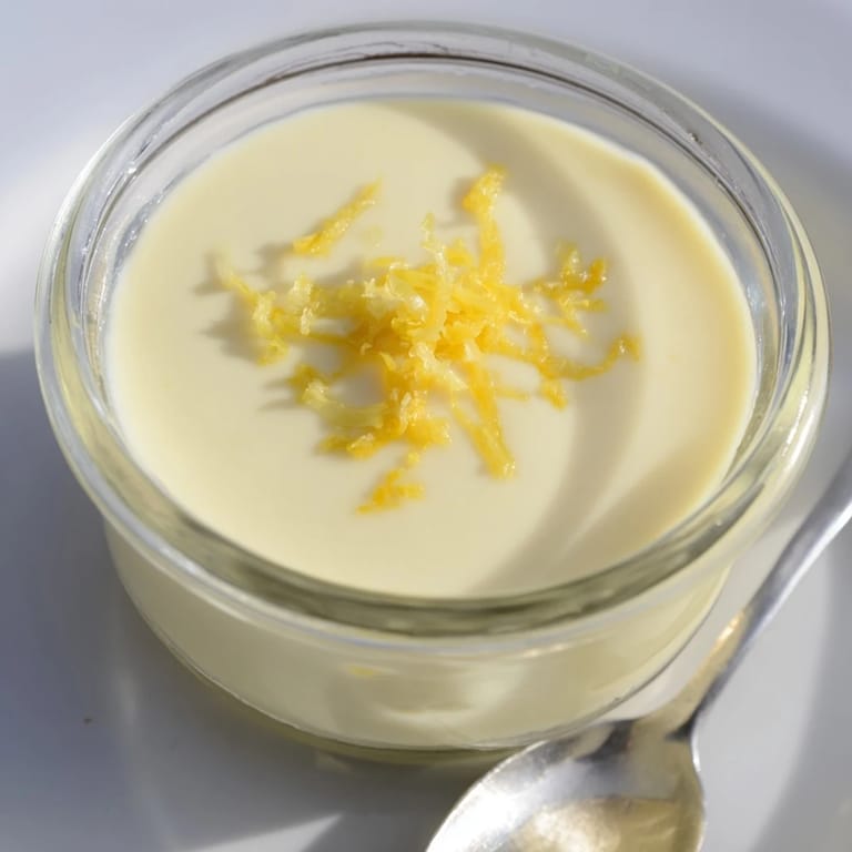 The finished 3-Ingredient Lemon Posset is creamy white, garnished and set delightfully in glass dishes.