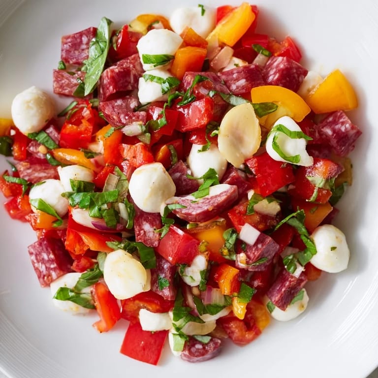 Bright Italian-inspired Crunchy Antipasto Chopped Salad with pepperoncini, olives, tomatoes, and cucumbers, garnished with fresh parsley and basil on a rustic table.