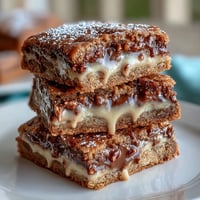 Decadent clotted cream cookie bars with white chocolate chunks, baked to golden perfection and cut into rich squares.