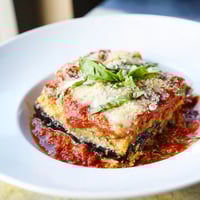 Golden-brown Eggplant Parmesan Lasagna, layered with creamy cheese and rich marinara sauce, steaming hot.