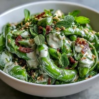 Vibrant snap pea and radish spring salad with creamy tahini dressing.